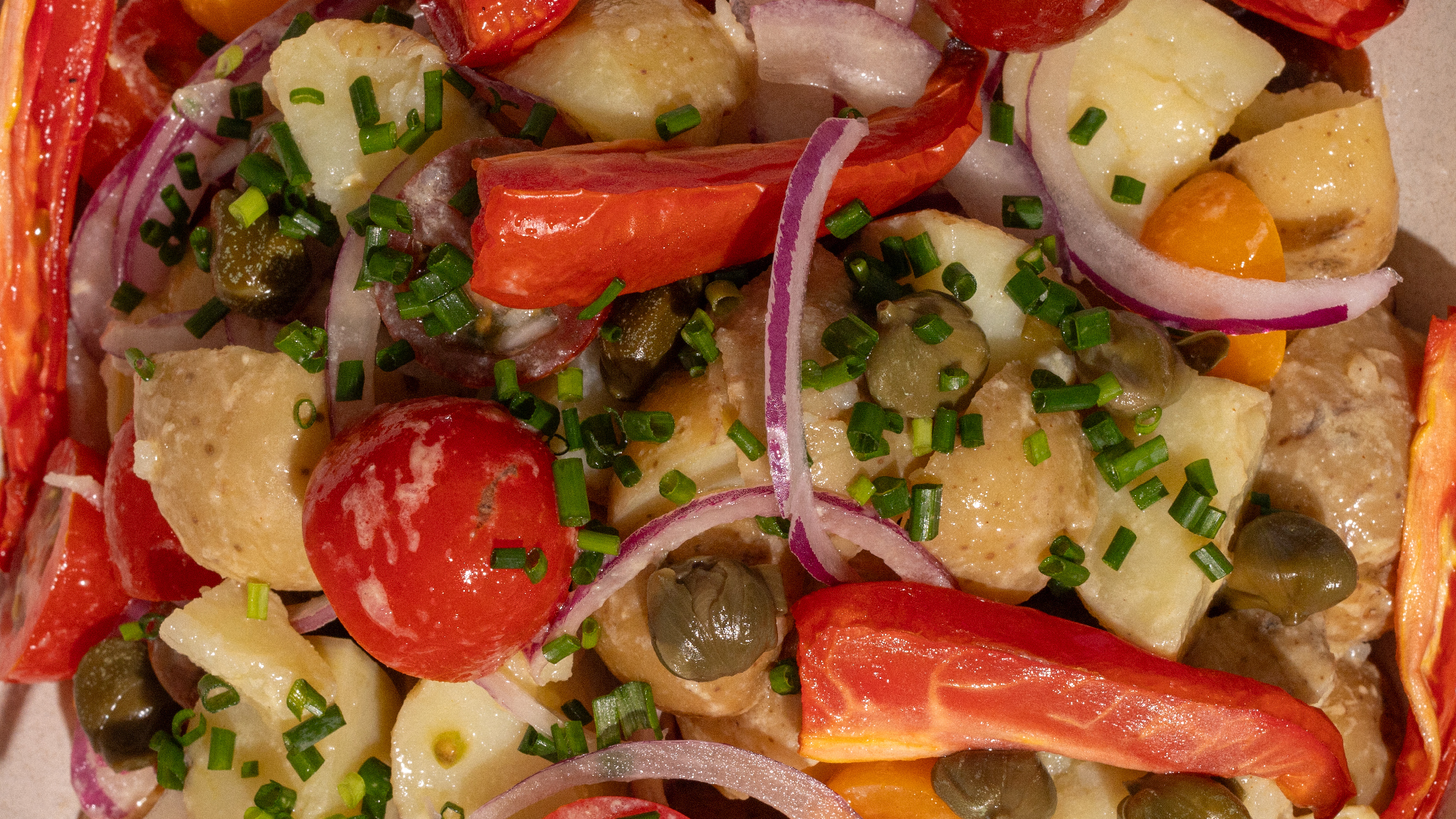 papines, alcaparras, tomates, cebolla morada, perejil y limón con aderezo mostaza y miel